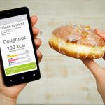 hands-holding-phone-and-donut